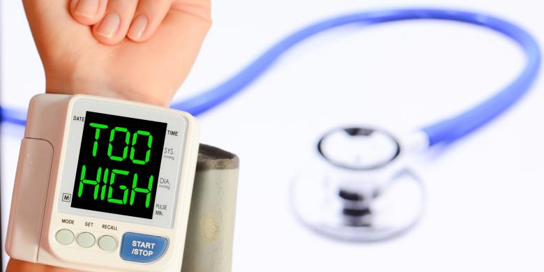 Wanita mengukur tekanan darah tinggi menggunakan alat tonometer di atas meja