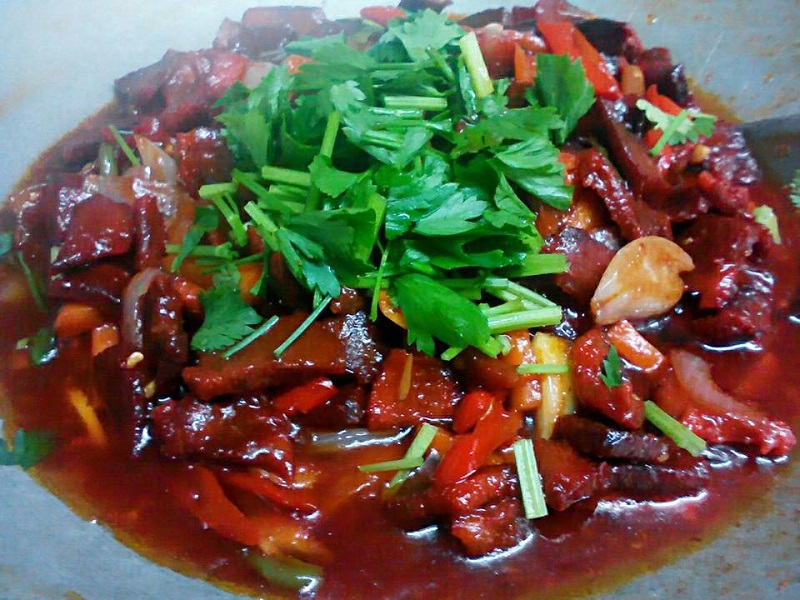 Hidangan daging masak merah Thai yang sedap di atas pinggan.