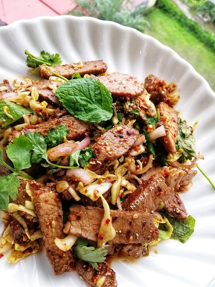 Hidangan Nue Nam Tok iaitu kerabu daging lembu panggang pedas dengan taburan herba.
