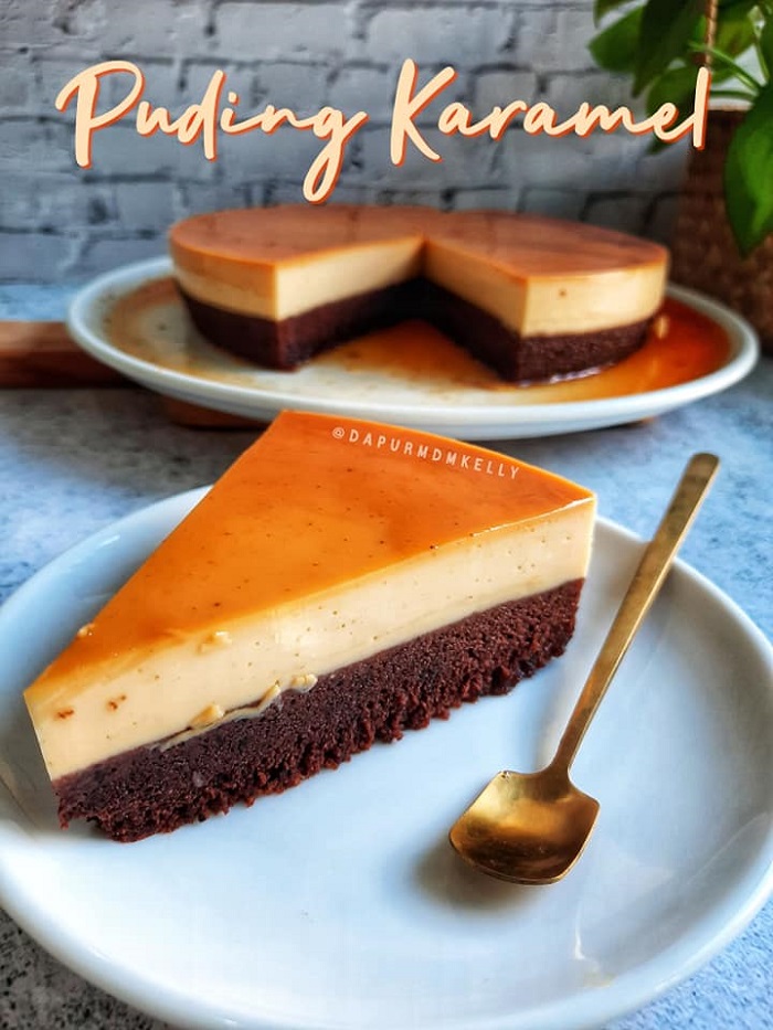 Potongan kek coklat puding karamel dengan lapisan karamel di atas dan cecair karamel mengalir di tepi kek.