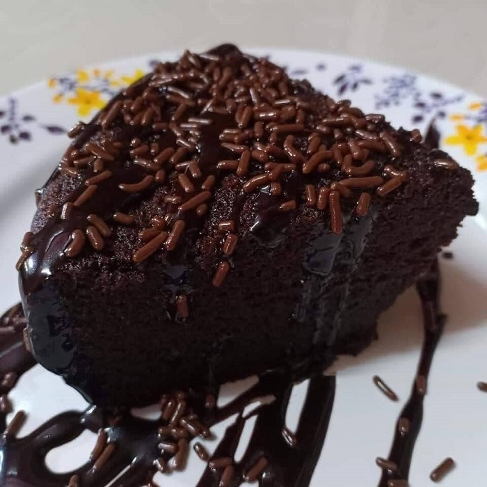 Potongan kek Milo kukus berwarna coklat yang lembut dan sedap dihidangkan untuk minum petang.