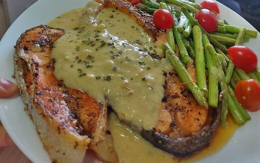 Salmon grille dengan sos lemon di atas pinggan