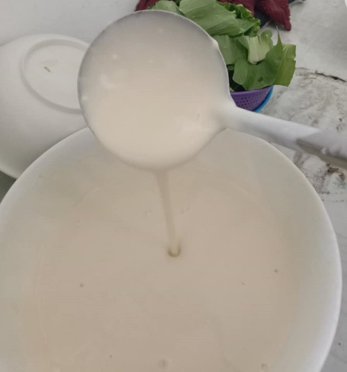 Adunan tepung dimasak ke atas pinggan di dalam periuk berair