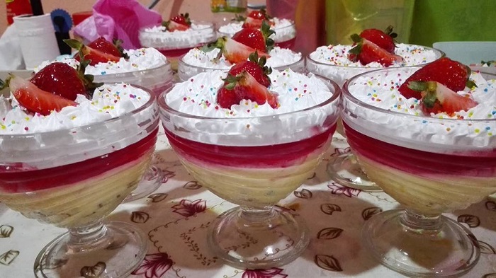Gambar puding triffle berlapis dengan kek, kastard, agar-agar dan hiasan whipping cream.