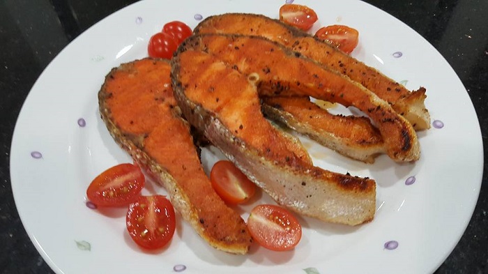 Hidangan ikan salmon grill disajikan bersama sos putih dan sayuran salad yang menyelerakan