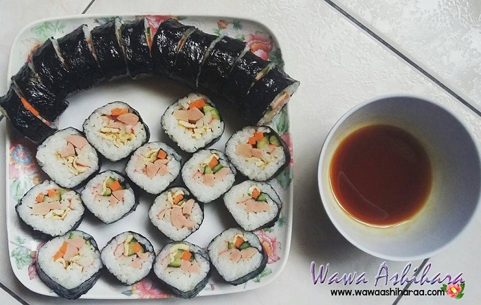 Imej kimbap roll Korea yang telah siap dipotong menampakkan inti nasi dan sayuran.