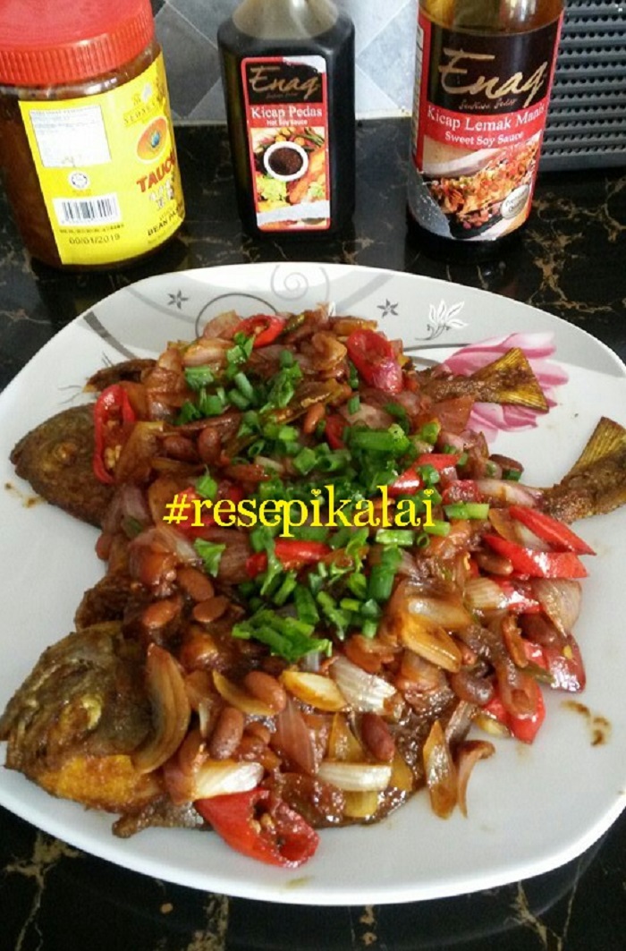 Ikan bawal masak taucu bersama hirisan cili, tomato dan daun ketumbar.