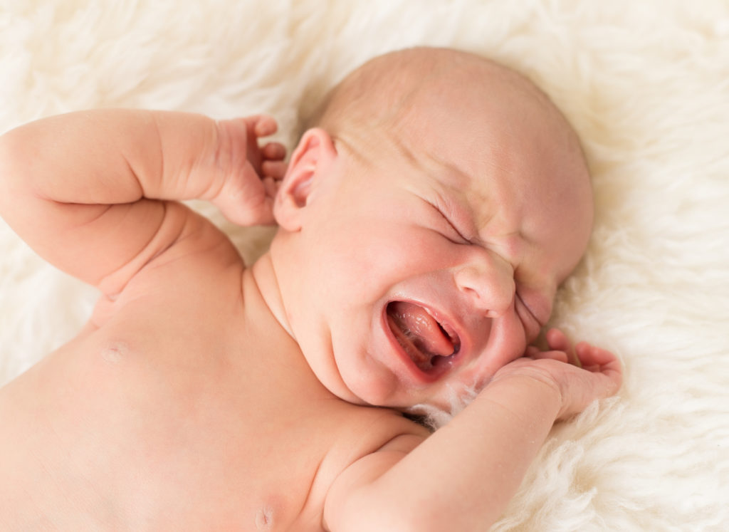 Gambar bayi sedang menangis kuat dengan wajah kemerah-merahan.
