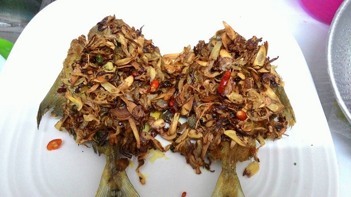 Ikan bawal goreng garing dengan taburan halia, bawang besar dan cili padi.