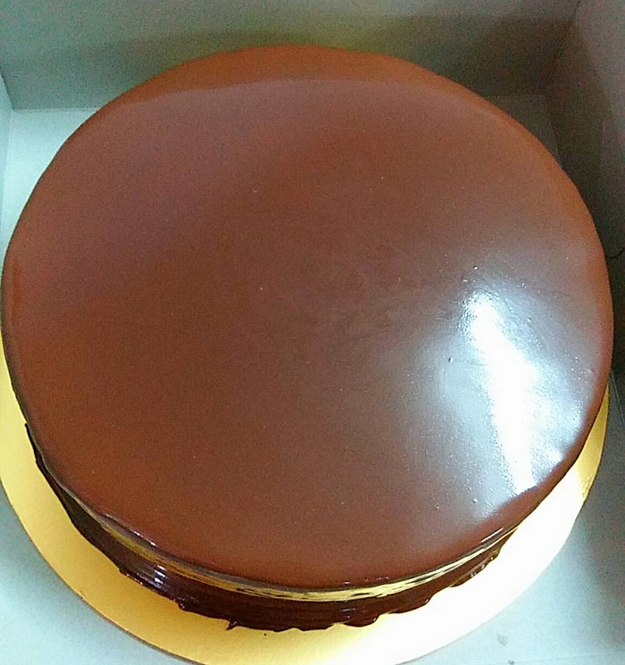 Mangkuk besen berisi coklat ganache cair untuk menyalut kek