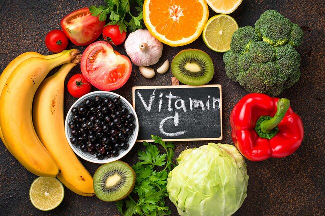 Tabung uji dengan bentuk oren, lemon dan buah beri yang melambangkan sumber vitamin C