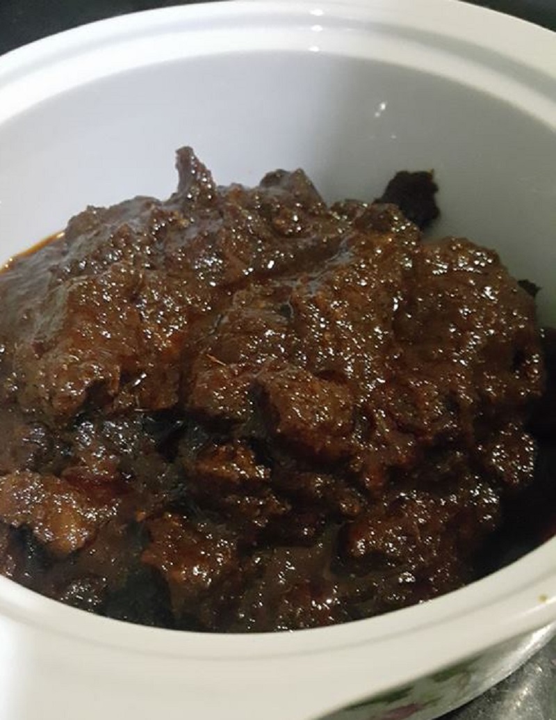 Sebuah pinggan berisi hidangan daging masak hitam berkuah pekat berwarna gelap.
