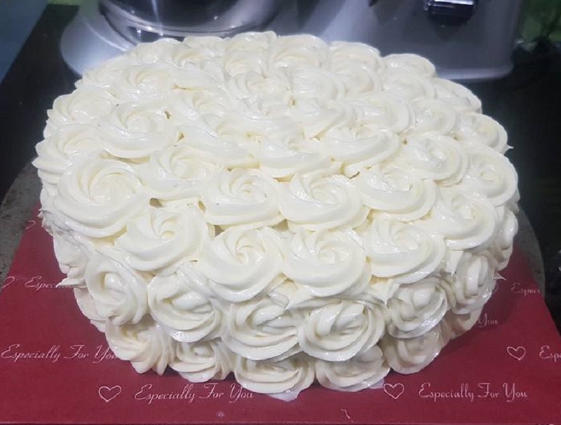 Kek Red Velvet dihias dengan topping cream cheese berbentuk ros