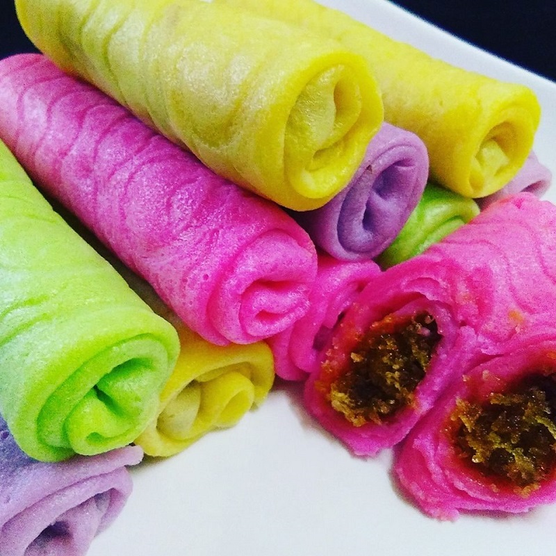 Gambar kuih ketayap berwarna hijau dilipat membulat dengan inti kelapa di tengah