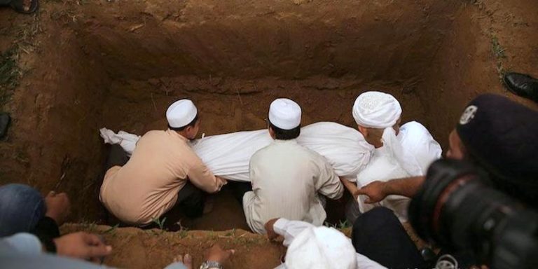 Orang membaca doa di tanah perkuburan untuk ibu bapa