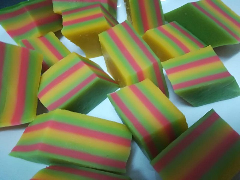 Gambar kuih lapis berlapis warna-warni merah, hijau dan kuning yang telah siap dipotong.