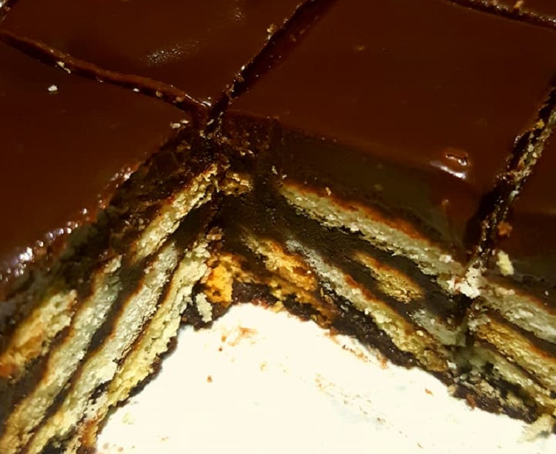 Imej kek batik Milo berlapis ganache coklat yang dipotong keping.