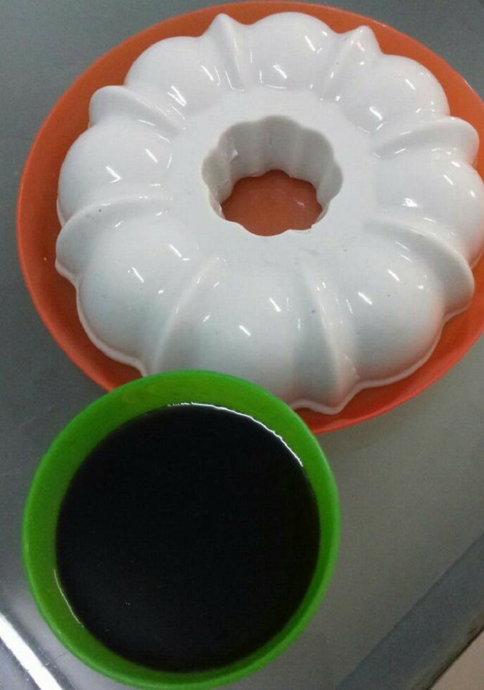 Sebekas kuih bubur sumsum putih dipotong kecil bersama siraman air gula melaka pekat.