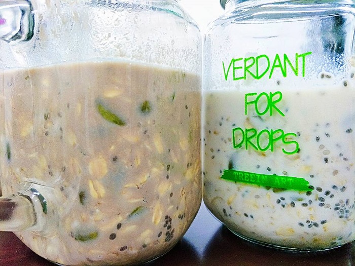 Bekas kaca berisi overnight oat dicampur dengan anggur hitam, kismis dan chia seeds.