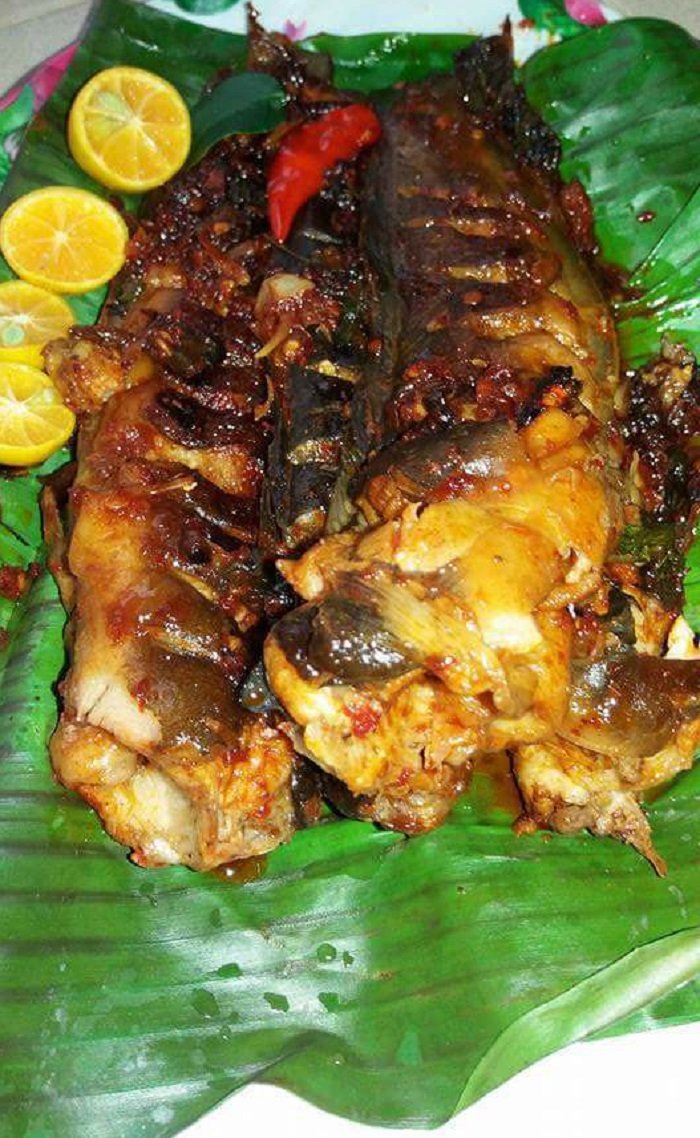 Ikan keli bakar bersama sambal di atas daun pisang dalam kuali leper