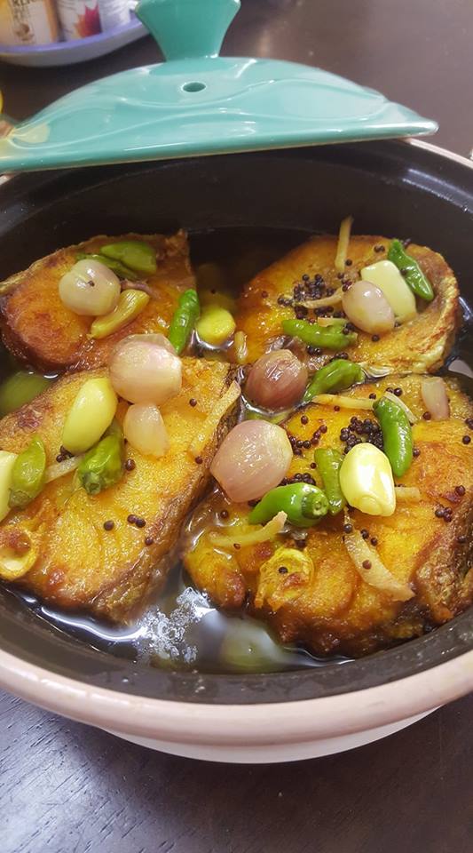 Hidangan ikan tenggiri masak cuka dalam pinggan, kelihatan kuah berserta hirisan bawang dan cili padi.