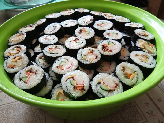 Sekeping sushi yang telah siap dipotong menggulung dengan nasi, seaweed, timun, dan sambal bilis hitam.