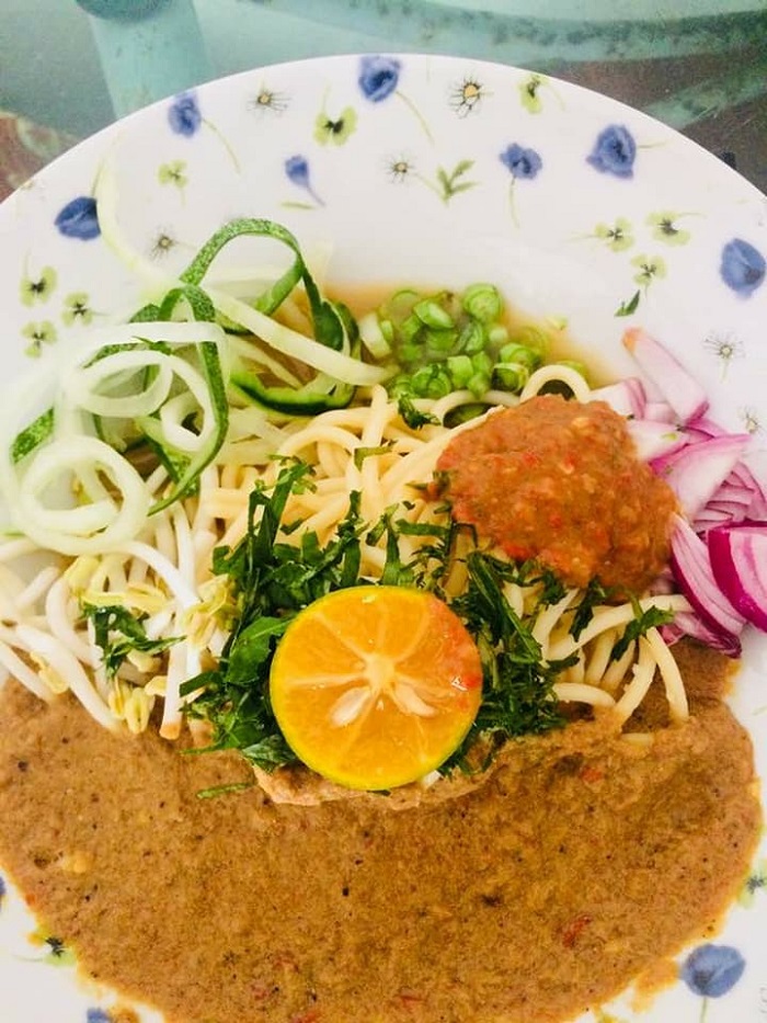 Sebungkus laksa johor dengan kuah pekat disajikan bersama ulam-ulaman