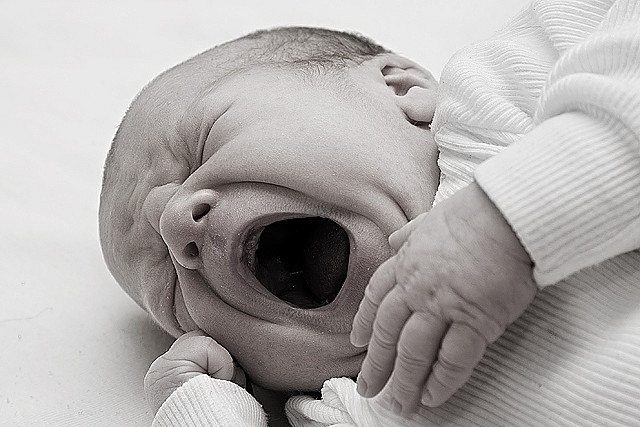 Gambar bayi yang sedang menangis diikat dengan kain