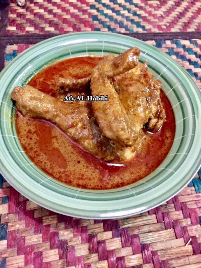 Sehidangan gulai ayam Kelantan berkuah kuning pekat dalam mangkuk.