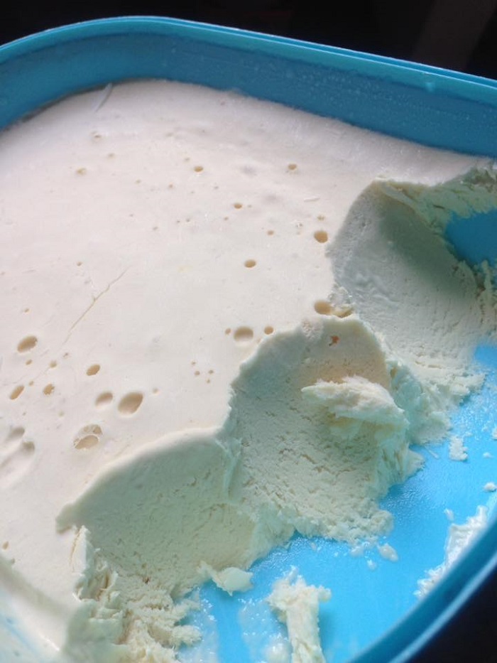 Mangkuk berisi aiskrim vanila homemade yang lembut dan menyegarkan.