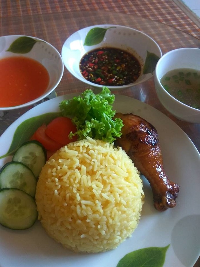 Empat pinggan nasi ayam sedap dengan ayam goreng, nasi berempah, dan sos cili.