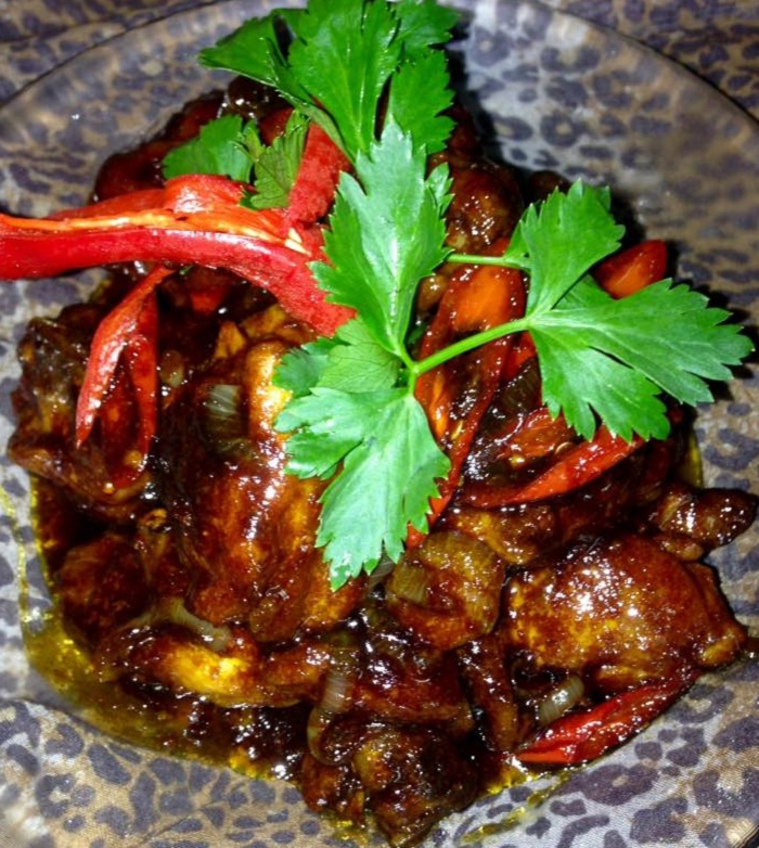 Hidangan ayam masak kicap pekat berwarna coklat keemasan dengan hirisan cili dan bawang besar.