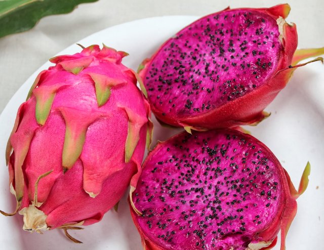 Buah naga merah yang dipotong menunjukkan isi putihnya
