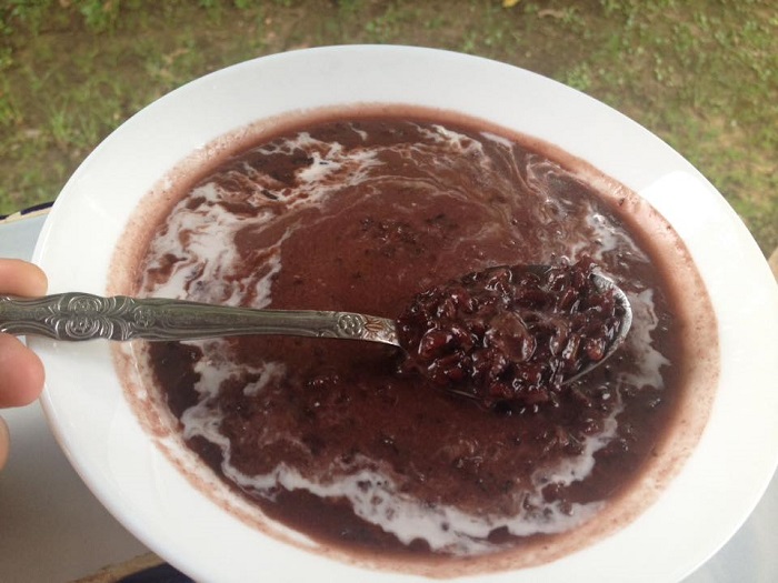 Sebotok bubur pulut hitam berkuah hitam pekat dihidangkan bersama santan pekat.