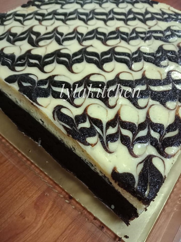 Sekeping brownies cheese marble yang dibakar dengan corak menarik di atas lapisan cheese.