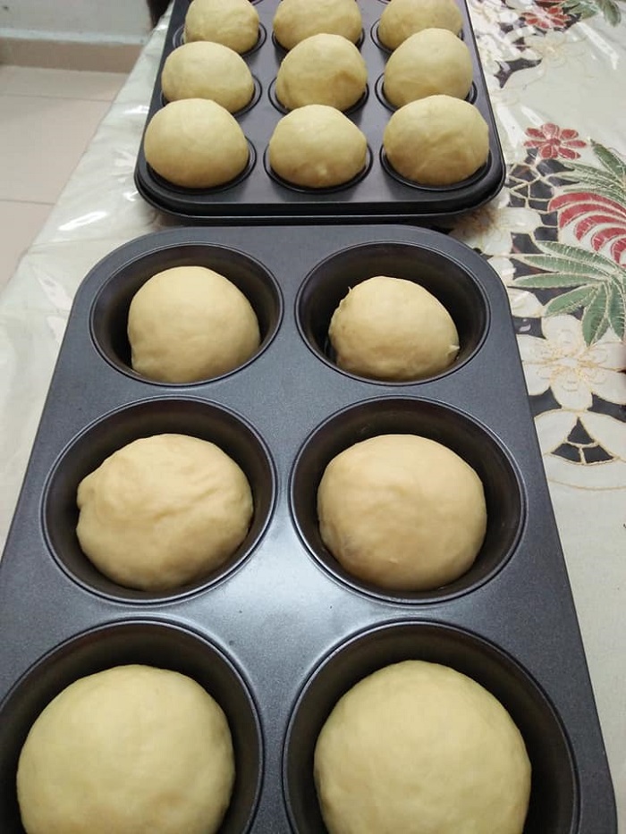 Proses melipat dan memasukkan inti kacang merah ke dalam adunan roti