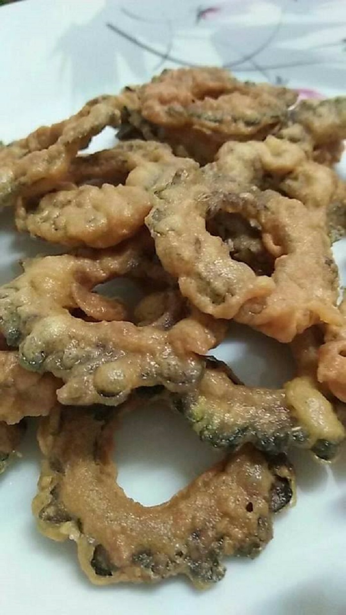 Gambar peria goreng yang rangup dan kekuningan di atas pinggan