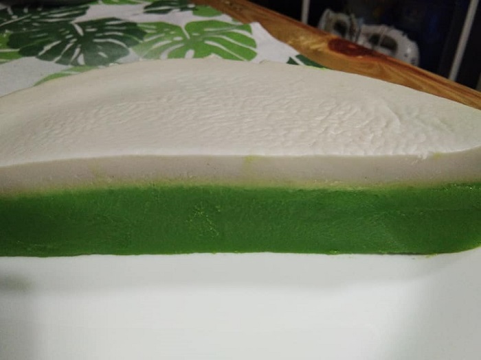 Potongan kuih talam pandan dua lapisan berwarna hijau dan putih yang nampak lembut dan wangi.