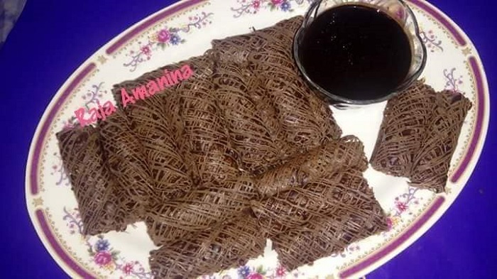 Gambar roti jala garing berwarna coklat dan biasa di atas pinggan.