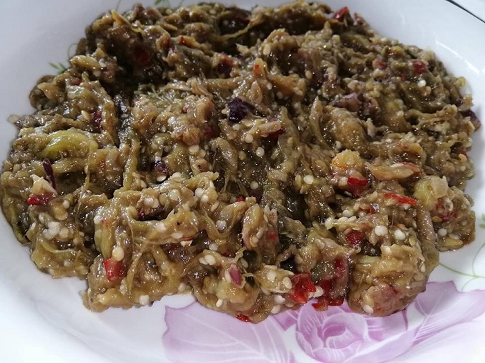 Gambar sambal terung bakar di atas pinggan dengan sambal cili padi dan ikan bilis yang menggigit selera.