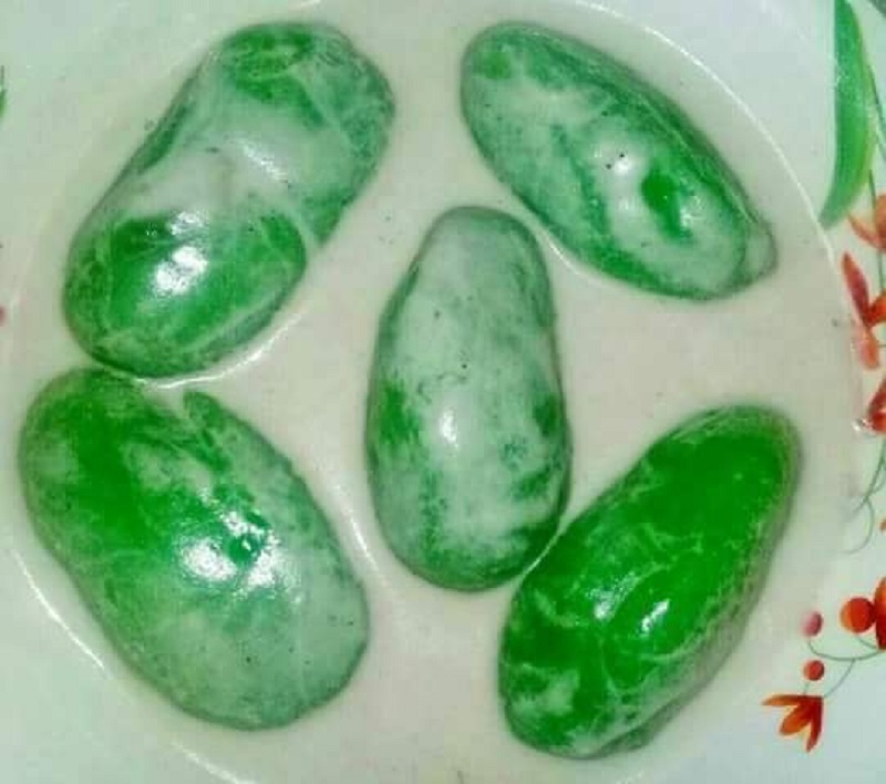 Sebuah mangkuk berisi kuih badak berendam berwarna hijau bersama kuah santan.