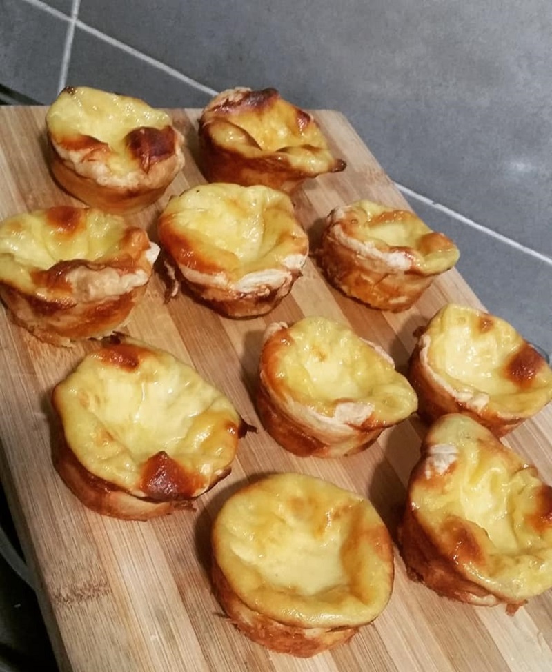 Tat telur Portugis bakar berwarna keperangan dalam loyang muffin.