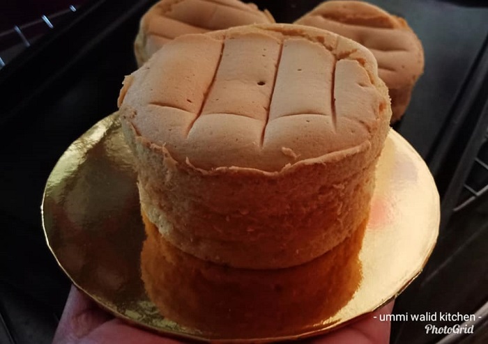 Kek span coklat yang telah siap dihias dengan aising dipotong untuk dihidangkan