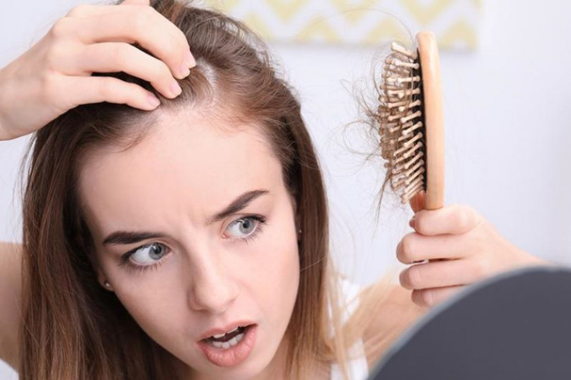 Wanita menyikat rambut yang gugur selepas bersalin