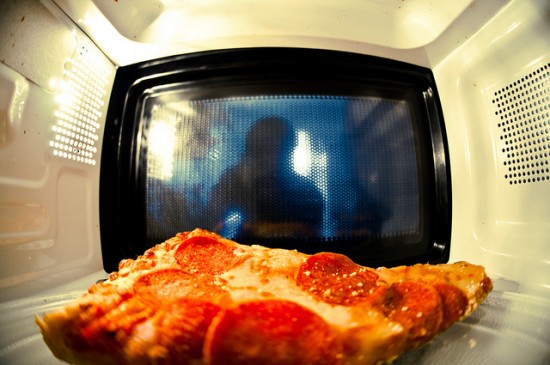 Petak microwave dengan mangkuk makanan sedang dipanaskan di dalamnya