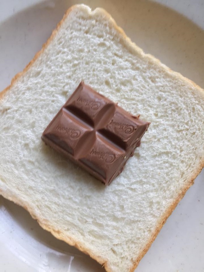 Proses menyapu coklat Cadbury ke atas roti