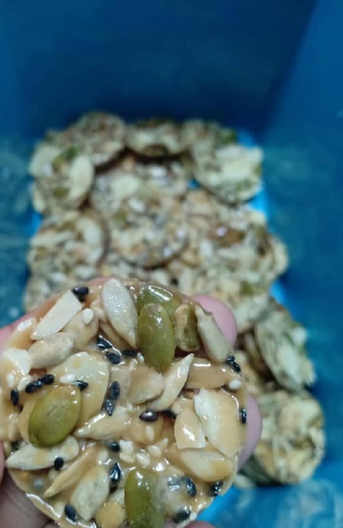Biskut Almond Crunchy berbentuk bulat berwarna perang keemasan diletakkan di atas piring.