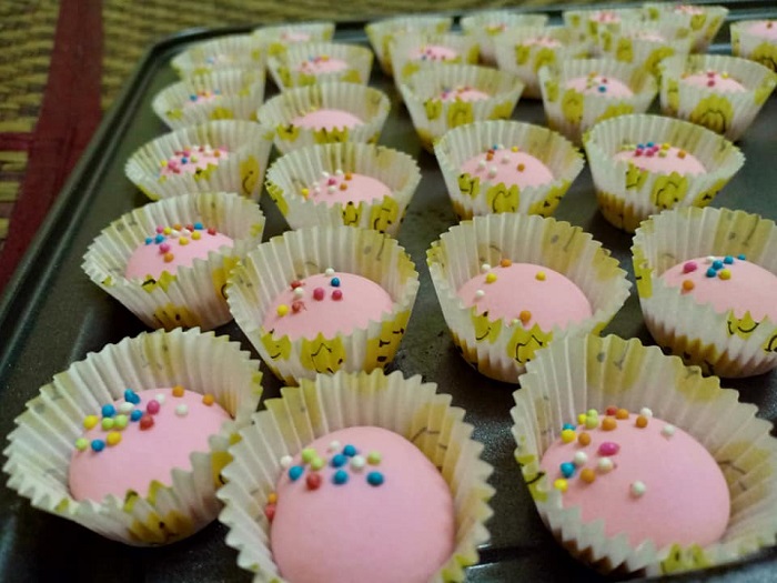Biskut susu bandung berwarna pink yang comel di atas meja.