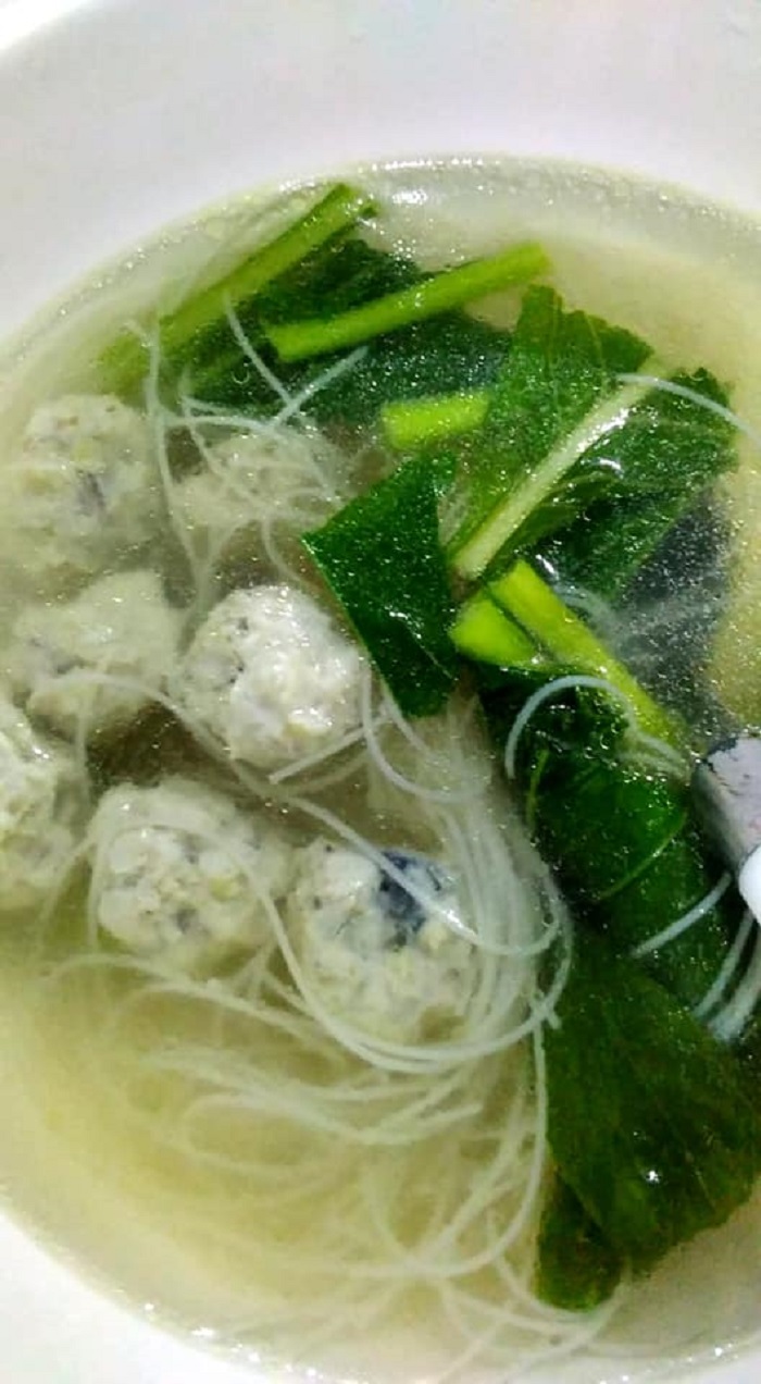 Mangkuk sup berisi bebola ikan dan sayur sawi