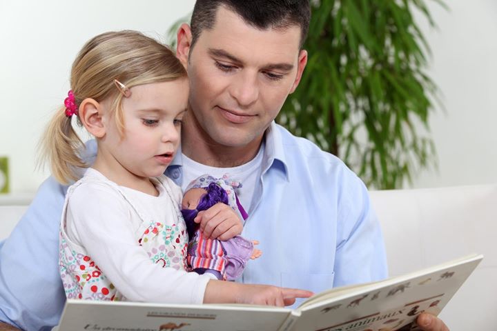 Ibu membaca buku cerita kepada anak kecil